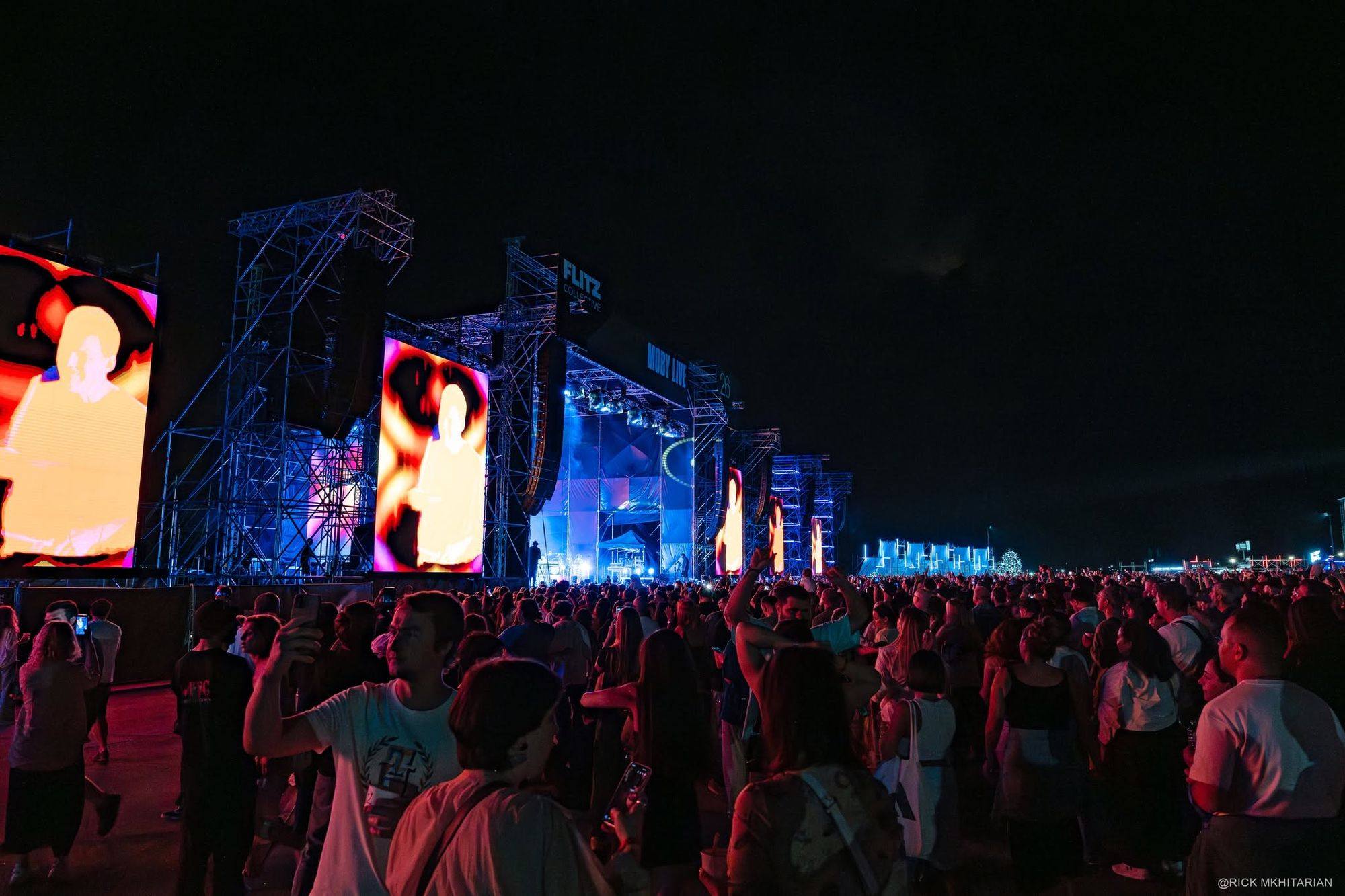 Stage and delay screens lit red and blue over the audience